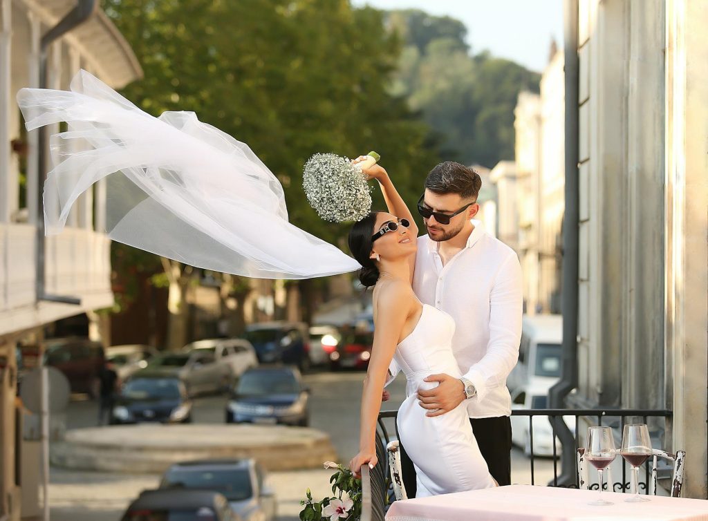Candid outdoor wedding portrait of a stylish couple in Tbilisi, capturing their joyful moment.