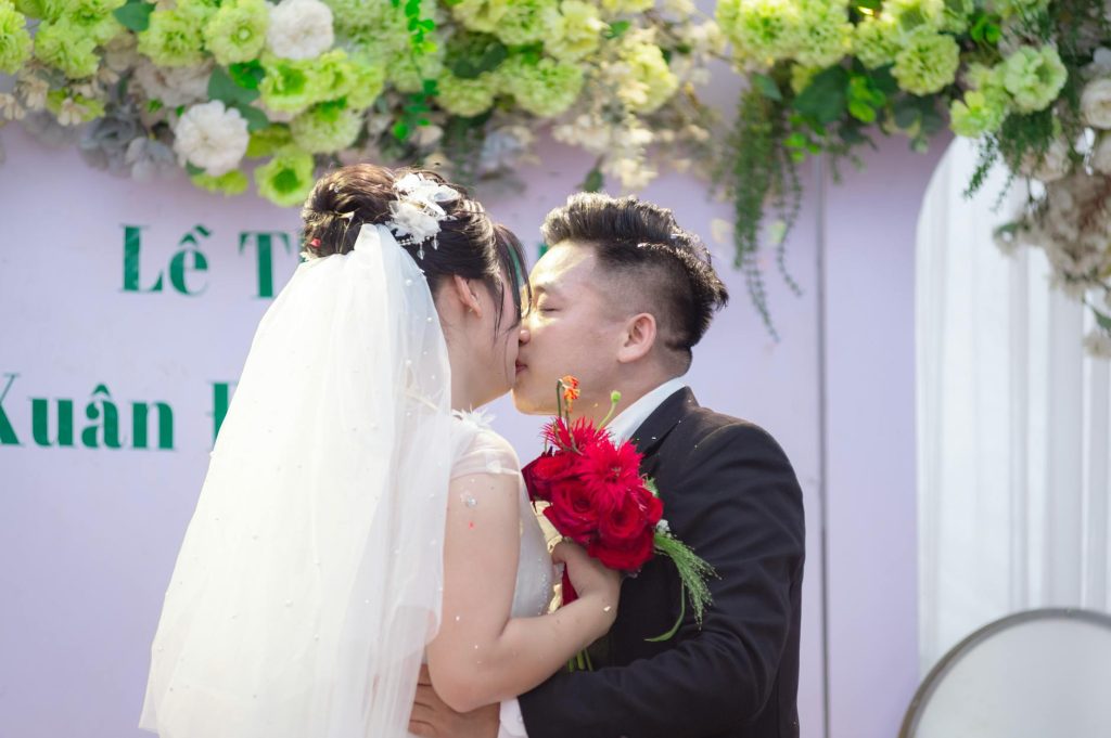 A bride and groom share a romantic kiss during their wedding ceremony in Hanoi, Vietnam.