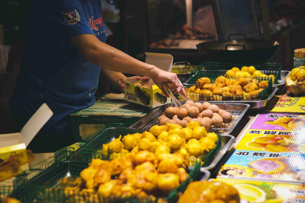 A bustling night market food stall showcasing an array of delicious fried snacks.