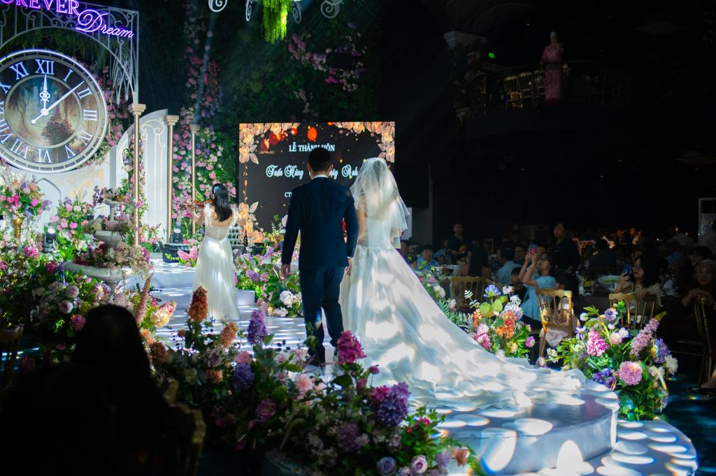 Beautiful wedding ceremony indoors with floral decor and couple in focus.