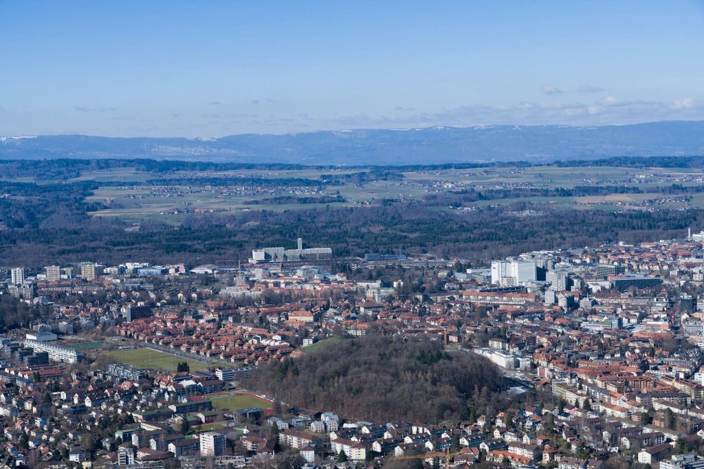 A breathtaking aerial view of Bern, Switzerland's cityscape with distant mountains.