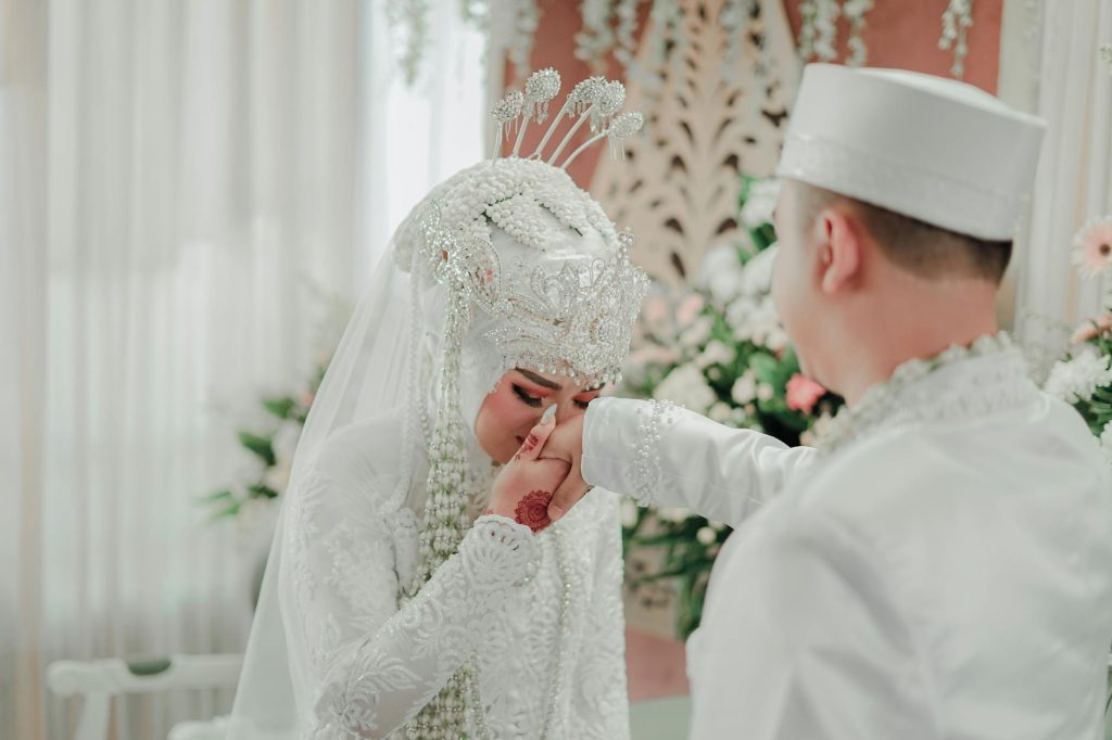 Elegant traditional wedding ceremony featuring bride and groom in cultural attire indoors.