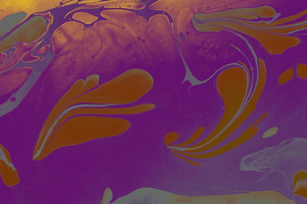Colorful fluid art with swirling purple and gold patterns creating a mesmerizing abstract design.