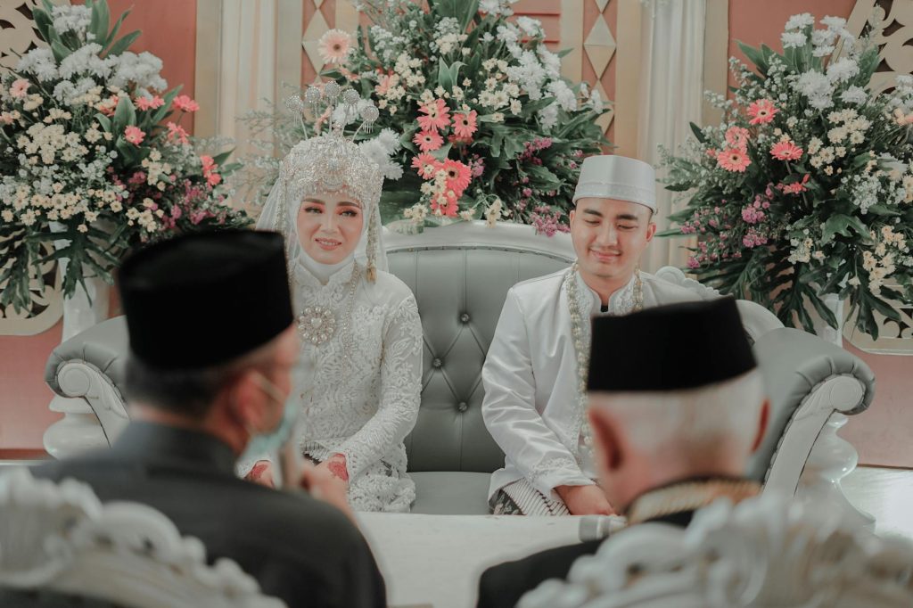 Bride and groom in traditional attire during a wedding ceremony indoors.