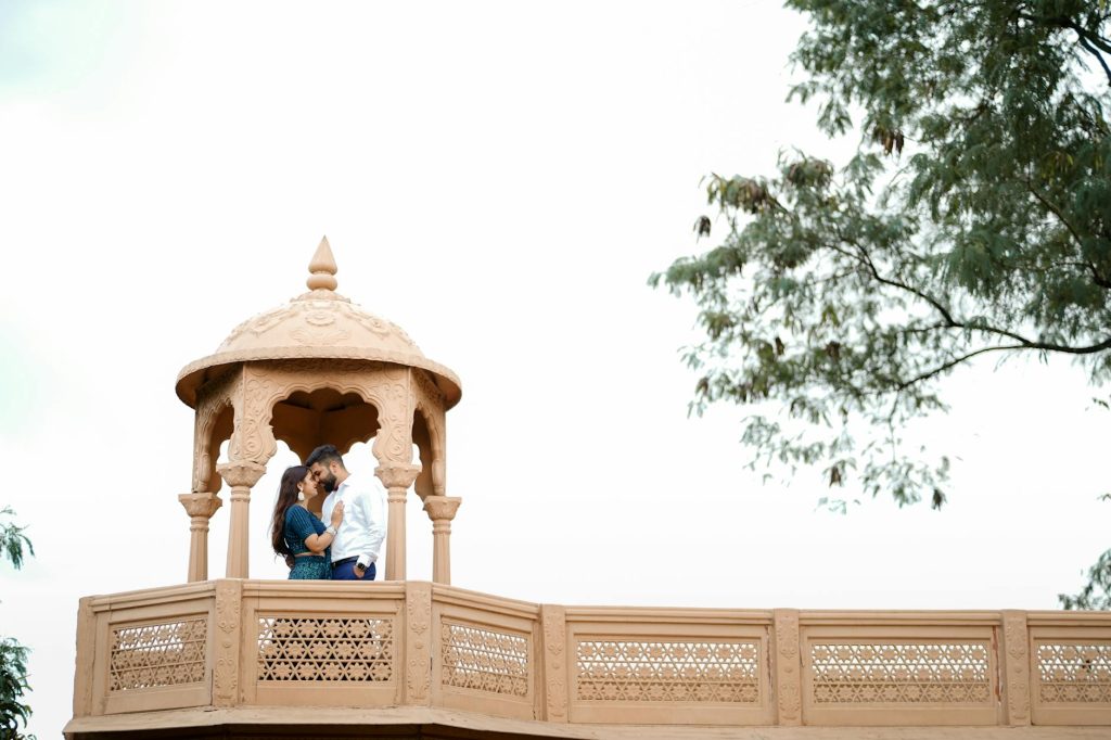 A couple sharing an intimate moment at a traditional Indian gazebo in Gurugram, India.
